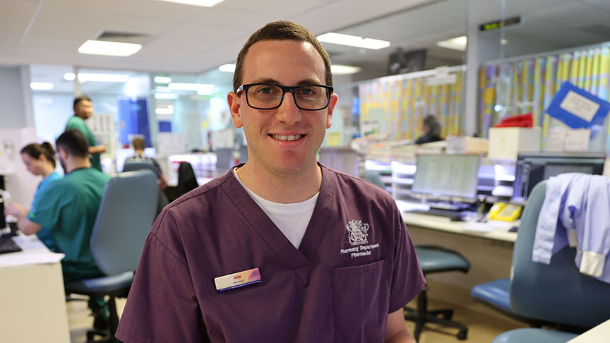 A man wearing purple scrubs sitting down