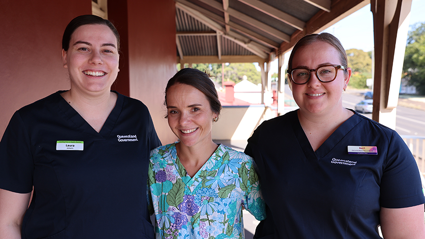 3 midwifes stood together outside of a building