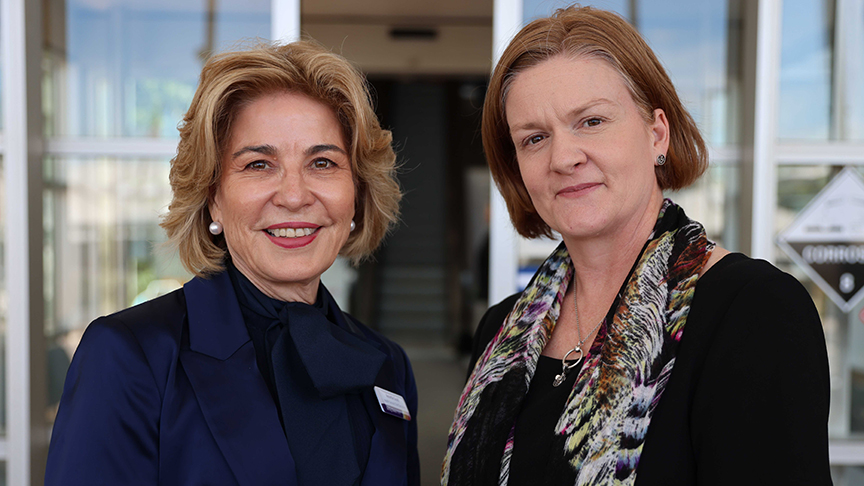Two women standing together outside a hospital
