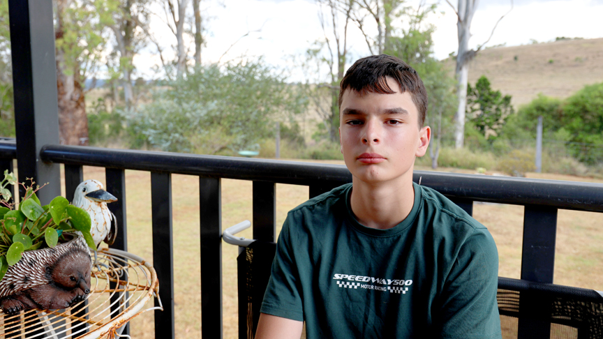 Young boy sitting on the deck of his Crows Nest home