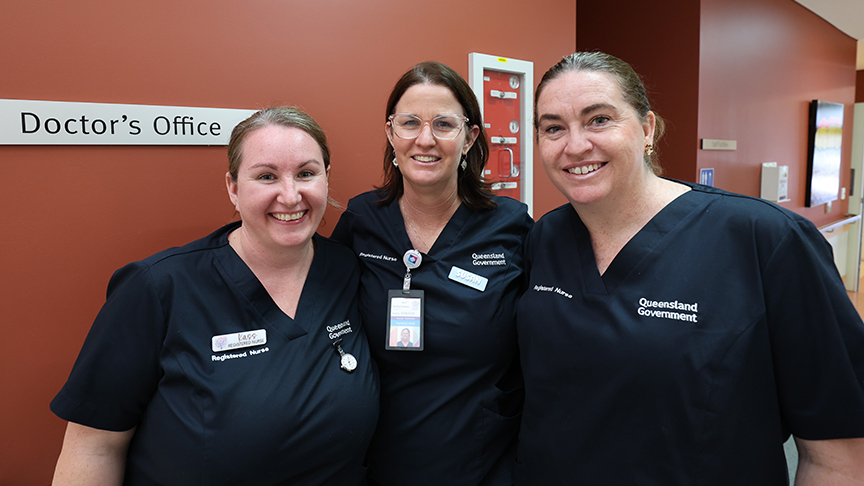 3 nurses stood in front of a doctor's office sign