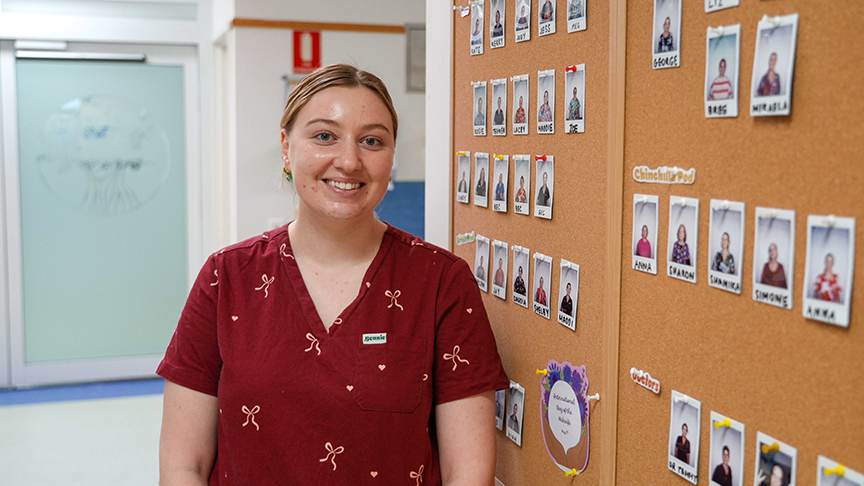 A woman wearing red scrubs smiles